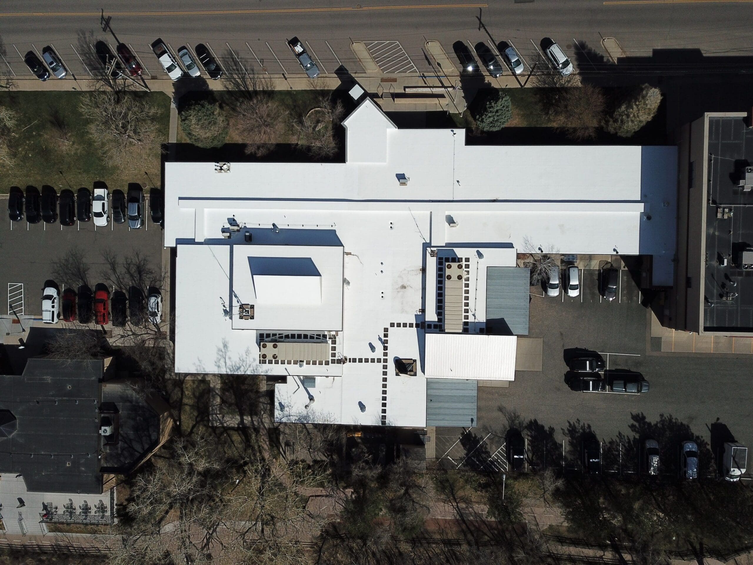 aerial view of a flat white commercial roofing project in Evergreen Colorado