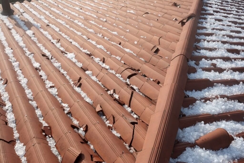 hailstones covering a terracotta tile roof