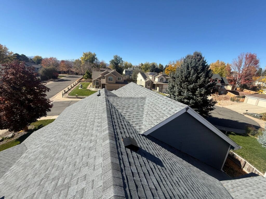 pitched gray asphalt shingle roofing system in a residential neighborhood of Highlands Ranch, CO