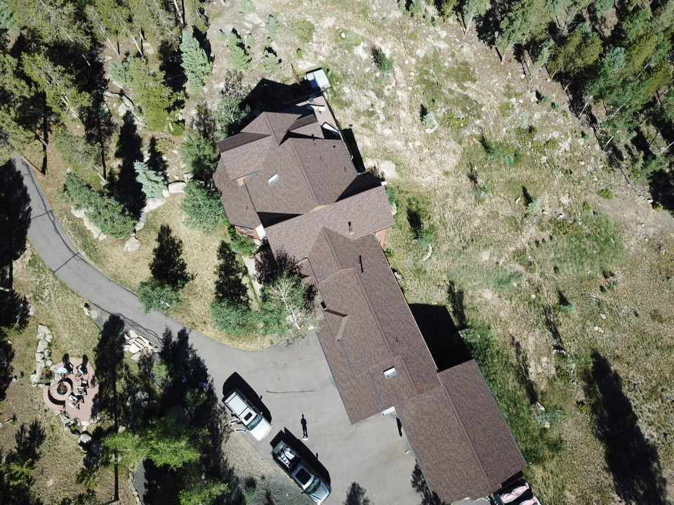 aerial view of a home with brown asphalt shingles