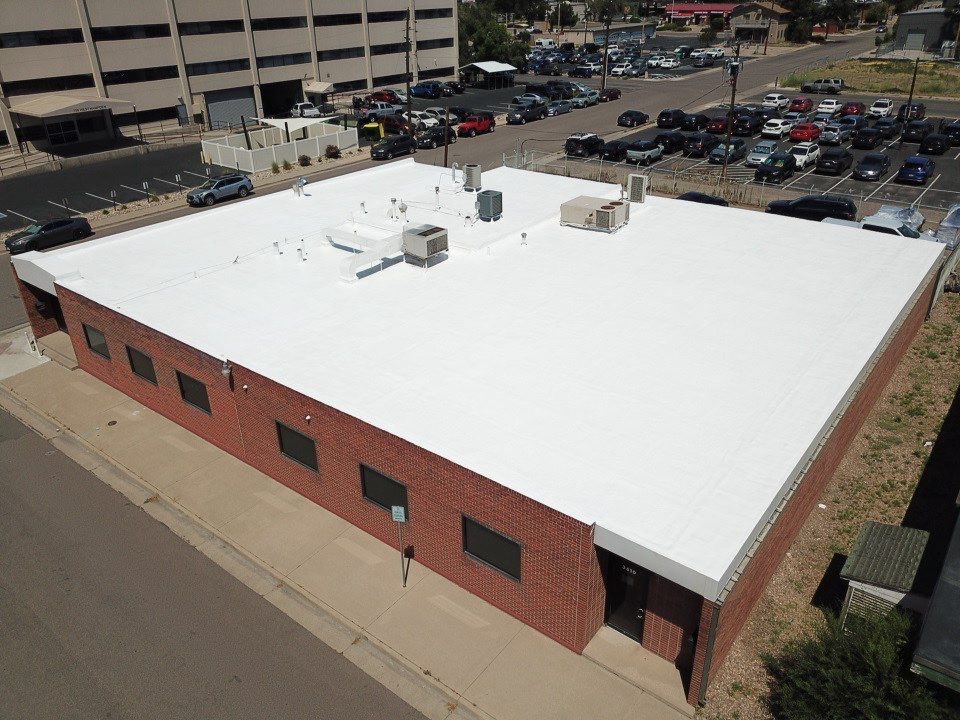 view from the top of a brick building in Denver with a flat roof with a white finish