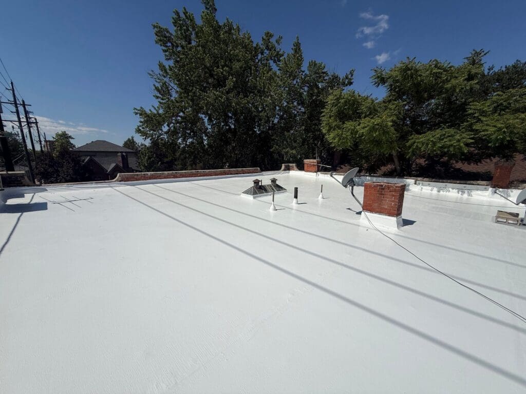 Denver flat roof repair project with trees in the background